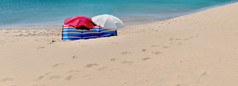 海滩雨伞挡风玻璃庇护人不可见独自一人海滩与细沙子和绿松石海
