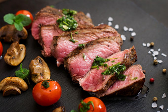 多汁的牛排媒介罕见的牛肉与香料和烤蔬菜