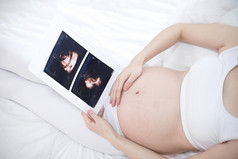 关闭怀孕了女人持有超声波扫描她的肚子