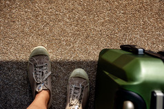 旅行夏天概念前视图年轻的旅行者运动鞋鞋子与行李站难看的东西脏混凝土地板上与阳光