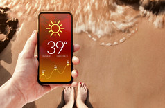 高温度天气预测显示移动屏幕热夏天阳光明媚的一天技术为生态概念沙子海滩与阳光背景前视图