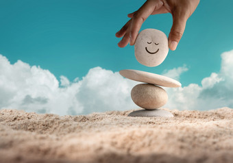 享受生活概念和谐和积极的心手设置自然卵石石头与微笑脸卡通平衡海滩沙子平衡身体心灵魂和精神精神健康实践