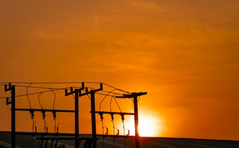 三相电权力为转移权力电网格高电压电波兰人工厂和屋顶建筑和橙色日落天空电权力为支持制造业行业