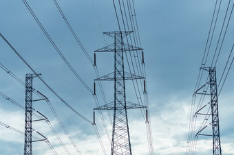 高电压电桥塔和电线对蓝色的天空和云底视图电桥塔高电压网格塔与线电缆传输行高电压网格塔