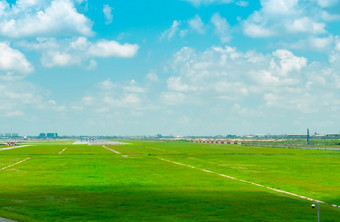 景观的机场跑道和绿色草场与蓝色的天空和白色云飞机滑行道飞机取从滑行道的机场航空业务城市景观难过的机场