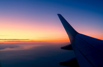 翼飞机与日出天际线飞机飞行的天空风景优美的视图从飞机窗口商业航空公司飞行飞机翼以上云国际飞行旅行在国外后新冠病毒