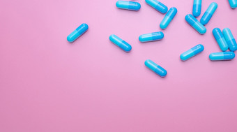 前视图胶囊药片粉红色的背景处方药物蓝色的胶囊药片制药行业药和药理学药物发展和新药物研究胶囊药片行业