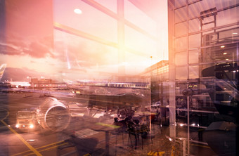 视图从玻璃窗口的机场建筑外乘客飞机对接的机场晚上商业飞机和服务卡车的机场空气运输跑道交通
