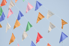 色彩斑斓的聚会，派对旗帜彩旗挂蓝色的天空为假期装饰