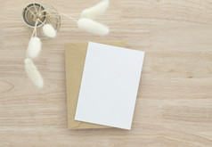 空白纸卡片空白问候卡邀请模型与干兔子尾巴草花瓶木表格木桌子上背景最小的木表格工作场所作文平躺模型