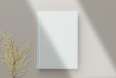 白色书空白封面模型米色背景与干花平躺模型