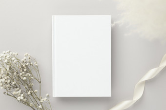 白色书空白封面模型米色背景与干花平躺模型