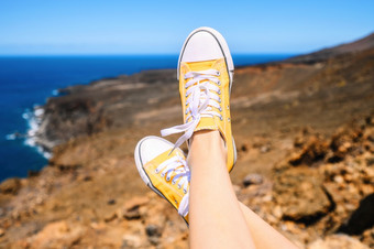 女人放松享受景观旅行者坐着岩石穿黄色的运动鞋夏天假期关闭高质量照片女人放松享受景观旅行者坐着岩石穿黄色的运动鞋夏天假期关闭