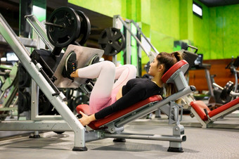 一边视图适合年轻的女运动员弯曲她的腿rsquo肌肉锻炼机的<strong>健身房</strong>高质量照片一边视图适合年轻的女运动员弯曲她的腿rsquo肌肉锻炼机的<strong>健身房</strong>