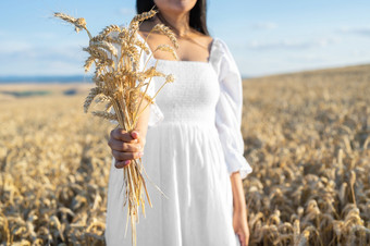 女人白色衣服站场与小麦人持有<strong>手包</strong>成熟的小穗收获季节高质量照片女人白色衣服站场与小麦人持有<strong>手包</strong>成熟的小穗收获季节