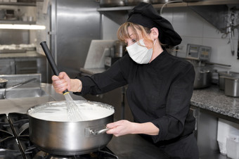 健康保护安全和流感大流行概念女老板烹饪穿保护脸面具而工作餐厅厨房高质量照片健康保护安全和流感大流行概念女老板烹饪穿保护脸面具而工作餐厅厨房