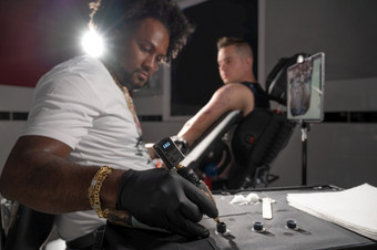 专业非洲美国纹身艺术家使纹身客户端手臂高质量摄影专业非洲美国纹身艺术家使纹身客户端手臂