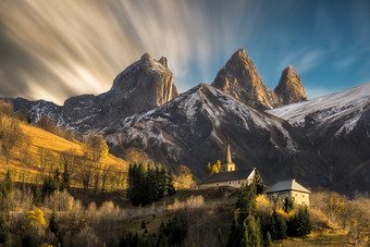 教堂村的法国阿尔卑斯山脉与山米高第一个秋天降雪与棕色（的）移动云和长曝光