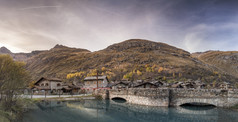 村的阿尔卑斯山脉与岩石房子和桥