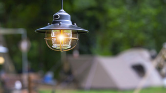 焦点古董黑色的野营灯笼与模糊背景帐篷野营区域自然公园