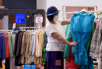 亚洲休闲女人穿保护面具选择夹克服装架时尚商店购物购物中心