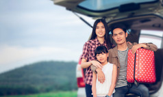 快乐小女孩与亚洲家庭坐着的车为享受路旅行和夏天假期露营者的