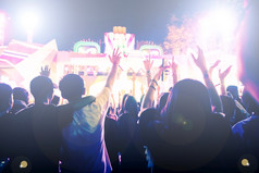 轮廓音乐会人群后视图节日人群提高他们的手明亮的阶段灯