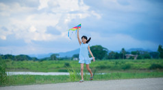 亚洲孩子女孩与风筝运行和快乐草地夏天自然