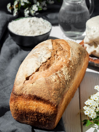 新鲜烤面包烘焙成分白色木表格特写镜头爱好烘焙小麦面包酵母<strong>首页</strong>健康的<strong>食物</strong>概念传统的工艺面包