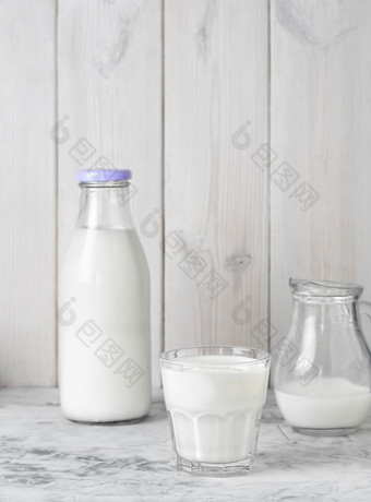 <strong>杯子</strong>与牛奶瓶牛奶和壶牛奶灰色的表格白色木背景与复制空间早餐概念健康的食物可重用的<strong>玻璃</strong>器皿<strong>杯子</strong>与牛奶瓶牛奶和壶牛奶灰色的表格