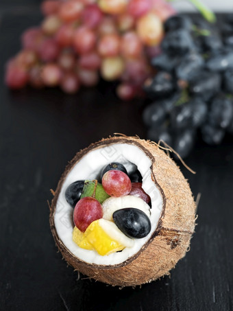 新鲜的<strong>水果</strong>是位于的一半椰子葡萄集群的背景<strong>水果</strong>是位于黑色的板岩石头新鲜的<strong>水果</strong>一半椰子黑色的变形石头背景健康的营养素食者饮食