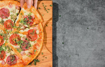 披萨与马扎雷拉奶酪意大利辣香肠和西红柿灰色的背景女孩手需要片披萨比萨 店广告海报概念与美味的披萨布局与免费的空间为文本