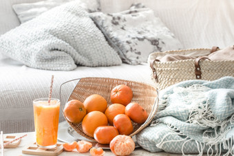 freshly-grown有机新鲜的橙色汁的室内的房子与绿松石毯子和篮子水果健康的食物维生素freshly-grown有机新鲜的橙色汁的室内的房子与绿松石毯子和篮子水果