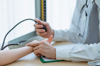 的医生使用两个手指检查的<strong>脉冲</strong>病人女人的手腕和检查血压力与汞血压计的医院医疗和医疗保健概念
