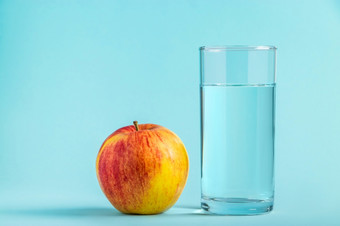 苹果和玻璃<strong>纯</strong>水蓝色的背景健康和饮食食物概念的地方为文本苹果和玻璃<strong>纯</strong>水蓝色的背景健康和饮食食物概念