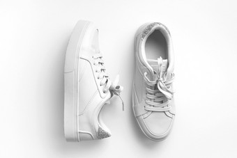 白色皮革运动鞋白色背景一对时尚时尚的白色体育运动鞋子运动鞋与复制空间为文本设计开销拍摄新白色运动鞋单色前视图平躺