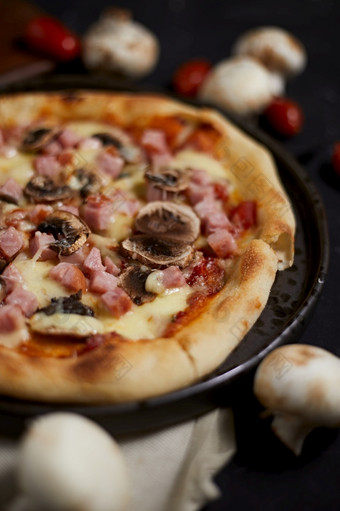 传统的意大利披萨与他和蘑菇服务板传统的意大利披萨与他和蘑菇