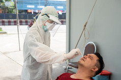 医生佩普西装和亚洲男人。病人检查新冠病毒标本执行鼻咽口咽拭子从鼻和口服医院执行鼻咽口咽拭子