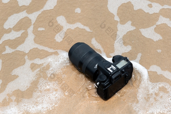 数码单反相机相机与长焦镜头海滩湿从水海波当旅行和测试使用的极端的环境演示防水摄影师数码单反相机相机海滩湿从水海波