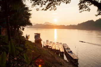 简单的生活金光照下来周围的湄公河河小<strong>木船</strong>返回首页的晚上蔬菜花园和当地的船前景山和日落背景銮prabang老挝的世界遗产小镇
