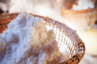 古老的方法沸腾盐水成纯盐kluea南泰国美丽的烟阳光照下来周围古老的盐坑和竹子篮子传统的文化岩石盐历史盐
