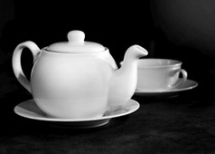 白色瓷茶杯和茶壶下午茶表格设置黑色的白色