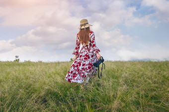 女人站草地和持有相机旅行概念古董语气