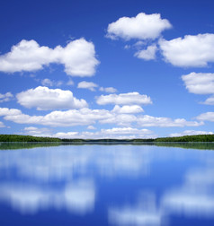 蓝色的夏天天空与白色云镜子完美的反射从湖表面