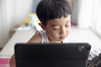 特写镜头亚洲男孩研究通过在线电子学习系统有视频调用遥远的类与老师使用移动PC首页新冠病毒冠状病毒研究在线电脑在家教育概念