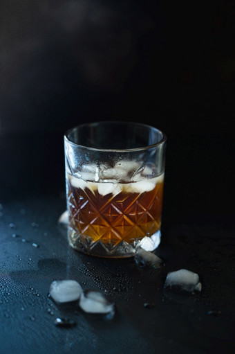 玻璃威士忌波本威士忌与冰黑色的石头表格玻璃威士忌与冰和广场玻璃水瓶玻璃苏格兰威士忌威士忌和冰