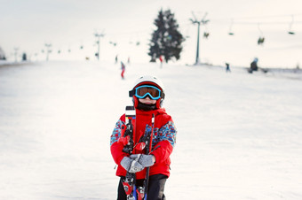 小可爱的男孩与滑雪板和滑雪装小滑雪的滑雪度假胜地