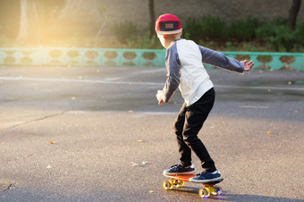 小城市男孩与一分钱滑板年轻的孩子骑的公园滑板城市风格城市孩子们孩子学习骑一分钱董事会