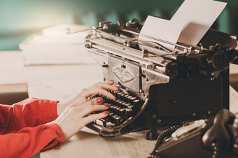 秘书老打字机与电话年轻的女人使用打字机业务概念复古的图片风格