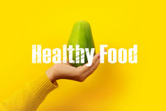 女手持有绿色木瓜黄色的背景健康的食物概念